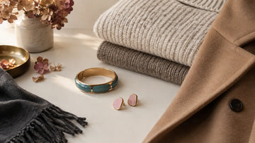 Colorful enamel jewelry styled with cream knitwear and a camel fall coat