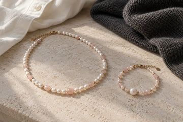 Editorial concept of a pearl necklace and bracelet paired by blush color but different scale