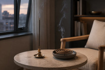 Stick incense and coil incense burning in separate heat-safe holders in a compact room