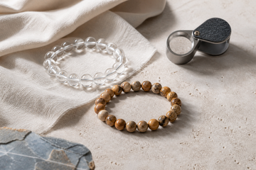Clear quartz and picture jasper bracelets arranged with a loupe for a practical buyer inspection