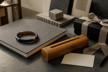 A generic enamel bangle and bamboo incense case arranged as refined gifts for design lovers